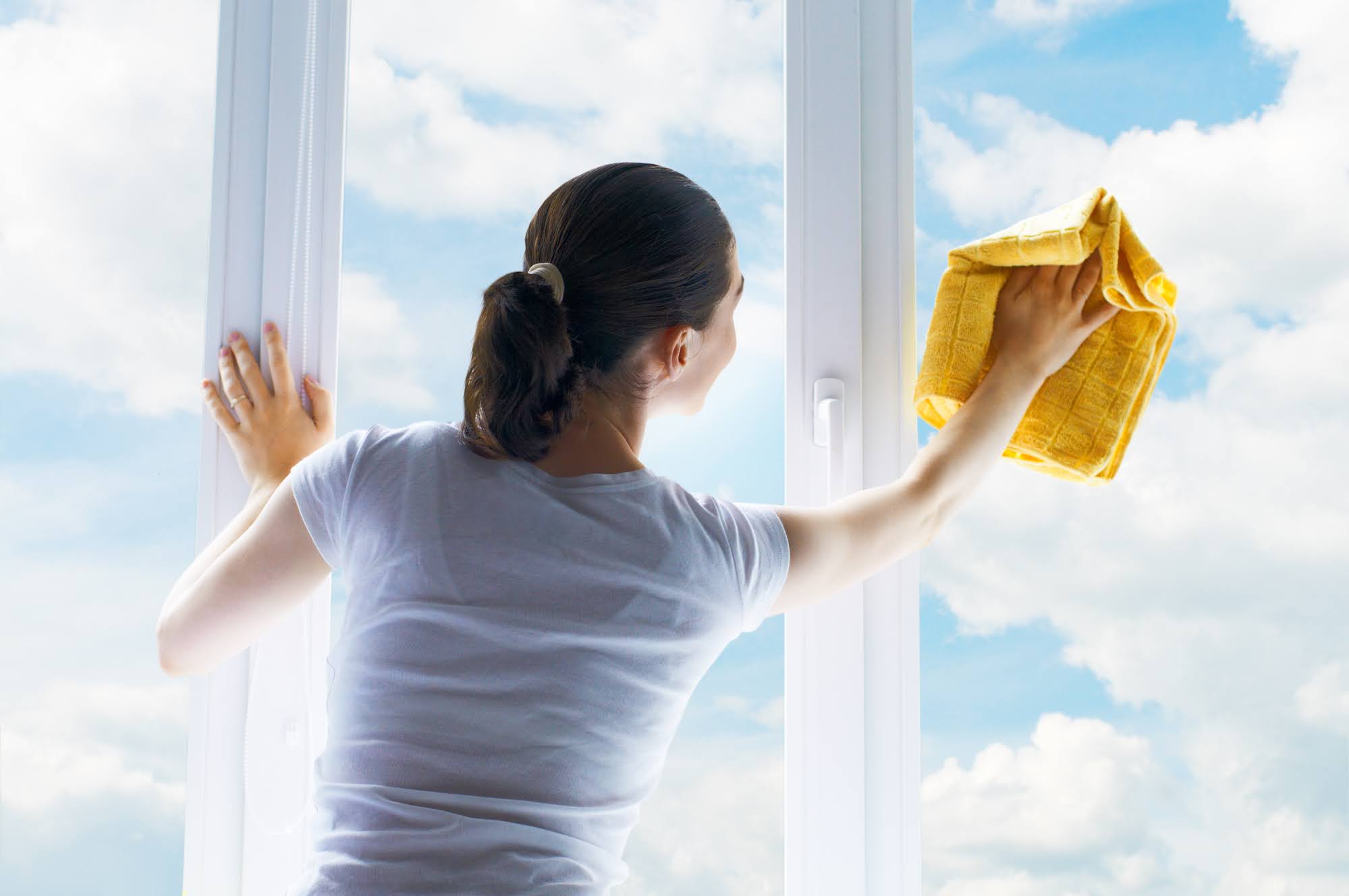 Woman with rag cleaning window